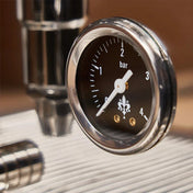 Close-up of a pressure gauge on a metallic surface with a blurred background