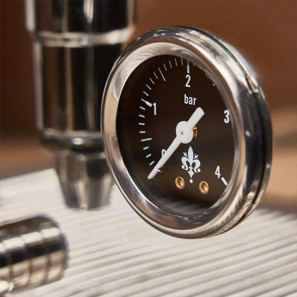 Close-up of a pressure gauge on a metallic surface with a blurred background