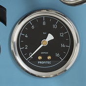 A close-up of a round Profitec pressure gauge with a black dial, silver chrome bezel, white needle, and gold-toned indicator dots, mounted on a light blue surface.